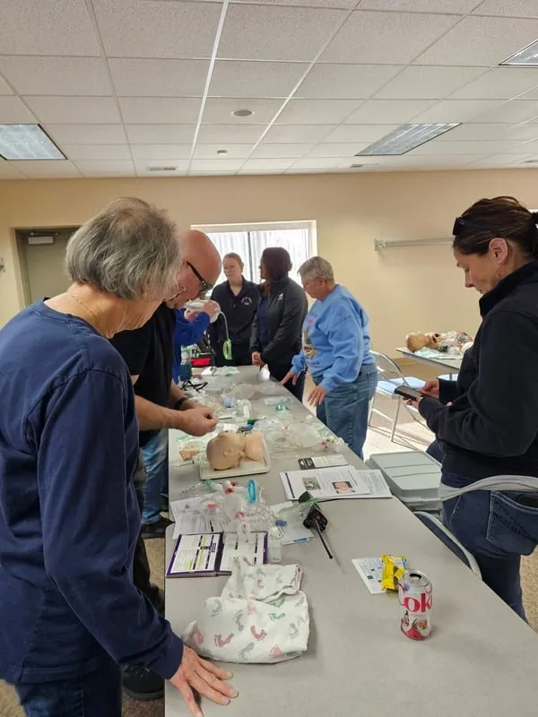 Providers practicing newborn stabilization skills around a training table.
